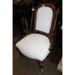 A LATE 19TH CENTURY CARVED WOODEN FRAMED NURSING TYPE CHAIR with upholstered back and overstuffed