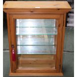 A MODERN PINE MIRROR BACKED DISPLAY CABINET with glass shelved interior