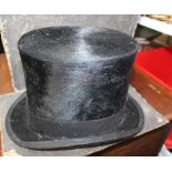 A SILK TOP HAT in remains of original box, together with a small pigskin Gladstone bag