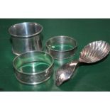 THREE HALLMARKED NAPKIN RINGS together with a silver scalloped bowl, tea caddy spoon