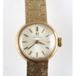 A ladies Omega wrist watch, the champagne-tone dial having hourly baton markers, on a 9ct yellow