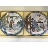 Twelve Chinese decorative wall plates with varying designs, all boxed.
