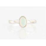 An opal ring, set with an oval opal cabochon, measuring approx. 5x7mm, stamped 585, ring size M½.