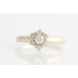 A diamond cluster ring, set with seven round brilliant cut diamonds in flower cluster formation,