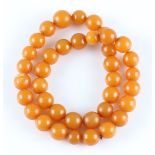 A string of butterscotch amber beads, comprising 38 spherical amber beads of differing sizes, length