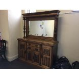 A sideboard with four doors and two drawers, with mirror to top and floral design columns to sides.