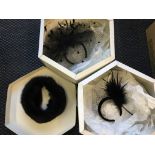 Two Harvey Nichols hat boxes containing a fascinator with black feather and netting as well as a