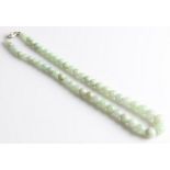 A string of green hardstone beads, comprising 52 graduated spherical beads, with seed pearl set