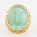An emerald ring, set with an emerald cabochon, measuring approx. 25x20mm, metalwork featuring linear