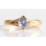 A single stone sapphire ring, set with a round cut sapphire, measuring approx. 5mm, yellow metal