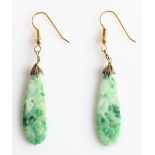 A pair of white/green jade dropper earrings, each featuring a piece of carved jade with floral