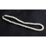 A choker length string of button pearls, fitted with a yellow metal sphere clasp, length approx.