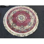 A large blue oriental patterned rug, with a round pink rug.