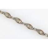 A diamond bracelet, comprising barrel shaped links set with tapered baguette cut diamonds, separated