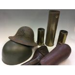 A selection of military items to include three shells, two helmets, a leather gun holster and