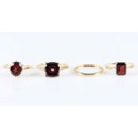 Four hallmarked 9ct yellow gold rings, three being set with garnets and one plain wedding band, ring