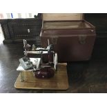 A miniature sewing machine in leather box.