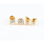 Two pairs of cubic zirconia stud earrings, set in unmarked yellow metal.