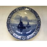 Two Delft wall plates, one depicting two boats at sea, signed H.W. Mesdag, one depicting windmill by