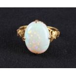 An opal ring, set with an oval opal cabochon, measuring approx. 15x11mm, with open metalwork gallery