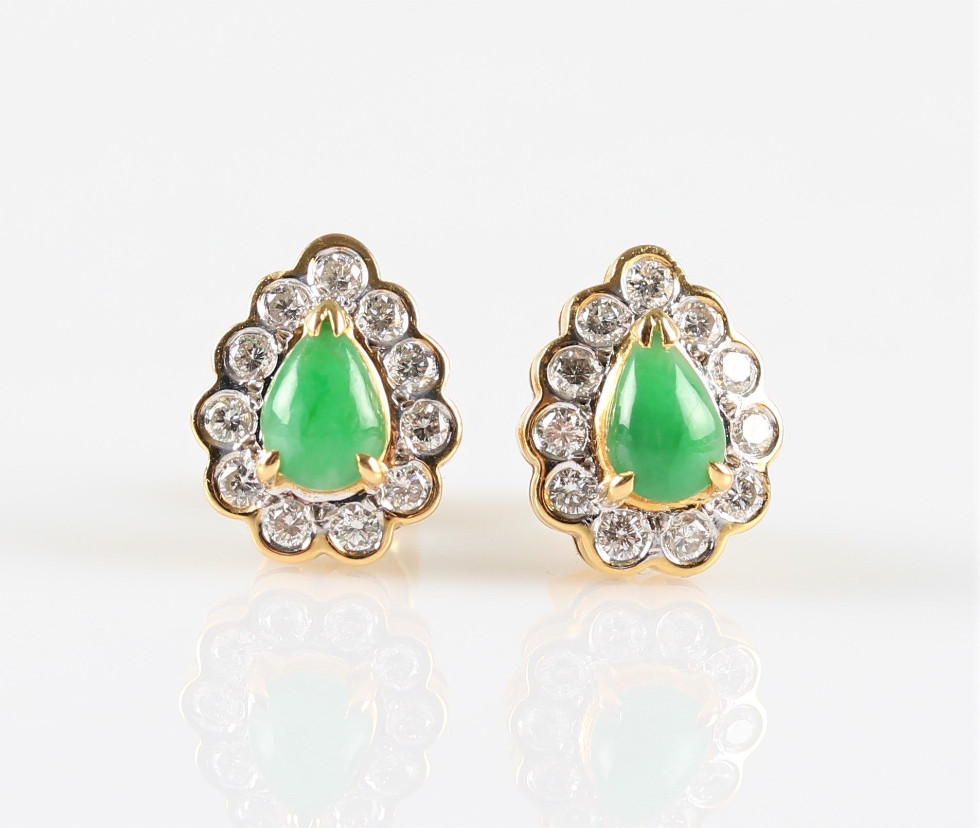 A pair of green jade and diamond cluster stud earrings, each set with a pear cut jade cabochon,