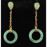 A pair of jade dropper earrings, each featuring a circular piece of carved jade suspended from a