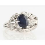 A sapphire and diamond dress ring, set with a central oval cut sapphire, measuring approx. 8x6mm,