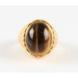 A tigers eye ring, set with an oval tigers eye cabochon, measuring approx. 18x14mm, metalwork having