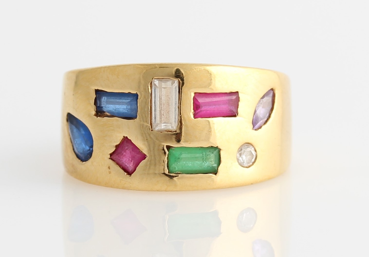 A multi-gemstone ring, the tapered band design set with variously cut rubies, synthetic blue spinel,