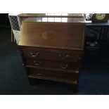 A mahogany three drawing writing bureau with oak interior.