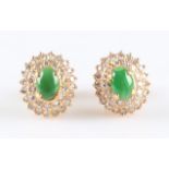 A pair of green jadeite jade and diamond cluster earrings, each set with an oval jadeite cabochon