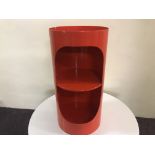 A Tomtom red painted cylindrical bedside cabinet.