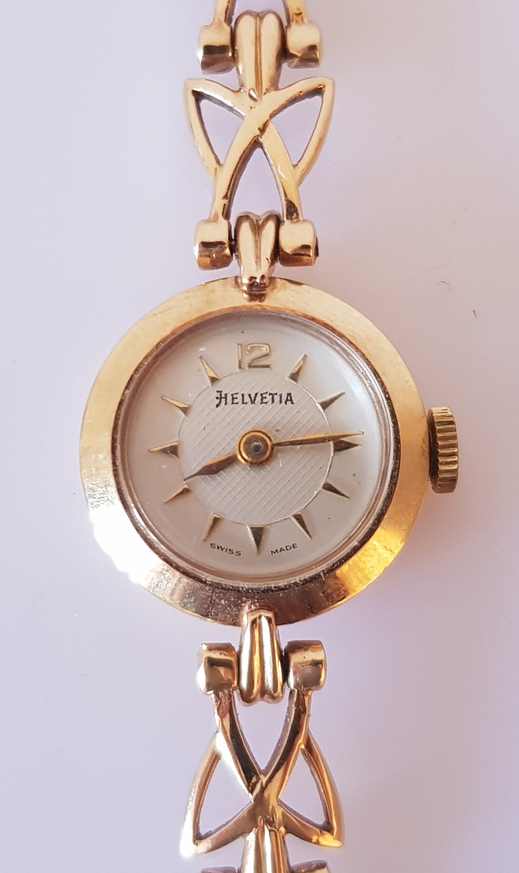 A ladies Helvetia wrist watch, on a hallmarked 9ct yellow gold open metalwork bracelet strap.