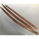 Three Aboriginal 'Woomera' spear-throwers, one straight, two curved, all flat, with blades to