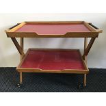 A mid-century red topped two-tier coffee trolley with x-form base. IMPORTANT: Online viewing and
