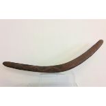 An Aboriginal boomerang, painted black and red with serpent-like design, length 77cm. IMPORTANT: