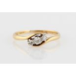 *A three stone diamond ring, the cross over design set with three old cut diamonds, total diamond