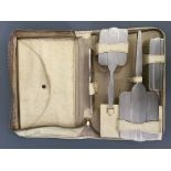 A silver Art Deco cased four piece brush set including a mirror, two brushes and comb, hallmarked