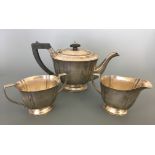 A silver three piece bachelors tea set including tea pot with ebony handle and finial with milk