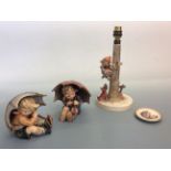 Two Goebel Hummel figurines boy and girl under umbrellas, one Goebel Hummel lamp base and small