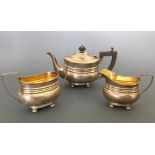A silver three piece bachelors tea set including tea pot with ebony handle and finial with milk