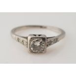 A diamond ring, set with a central round brilliant cut diamond, measuring approx. 0.30ct, flanked to