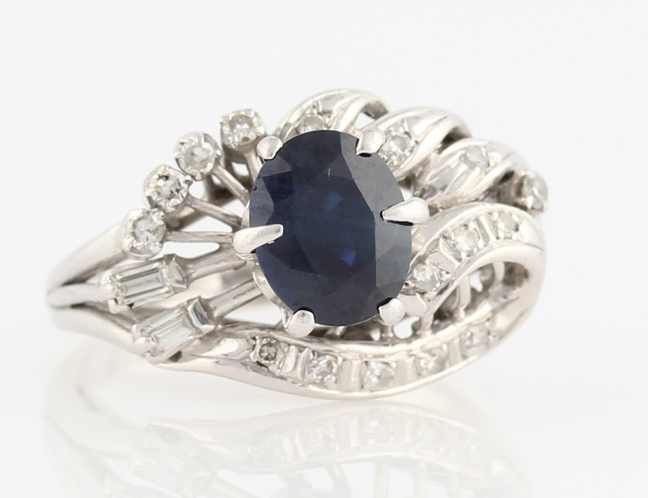 A sapphire and diamond dress ring, set with a central oval cut sapphire, measuring approx. 8x6mm,