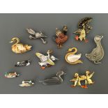 Twelve Jonette Jewelry pin brooches, including ducks, swan and duck with surfboard. IMPORTANT: