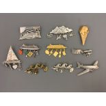 Ten Jonette Jewelry Company holiday pin brooches, some with hanging charms, including airplanes,