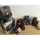 A box containing various cameras and accessories including Bolex 233, Rollei magic, Kodak Reina