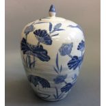 A blue and white oriental design lidded ginger jar decorated with crane and floral scene, height