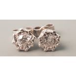 A pair of white metal diamond stud earrings, each earring approx. 0.50cts.