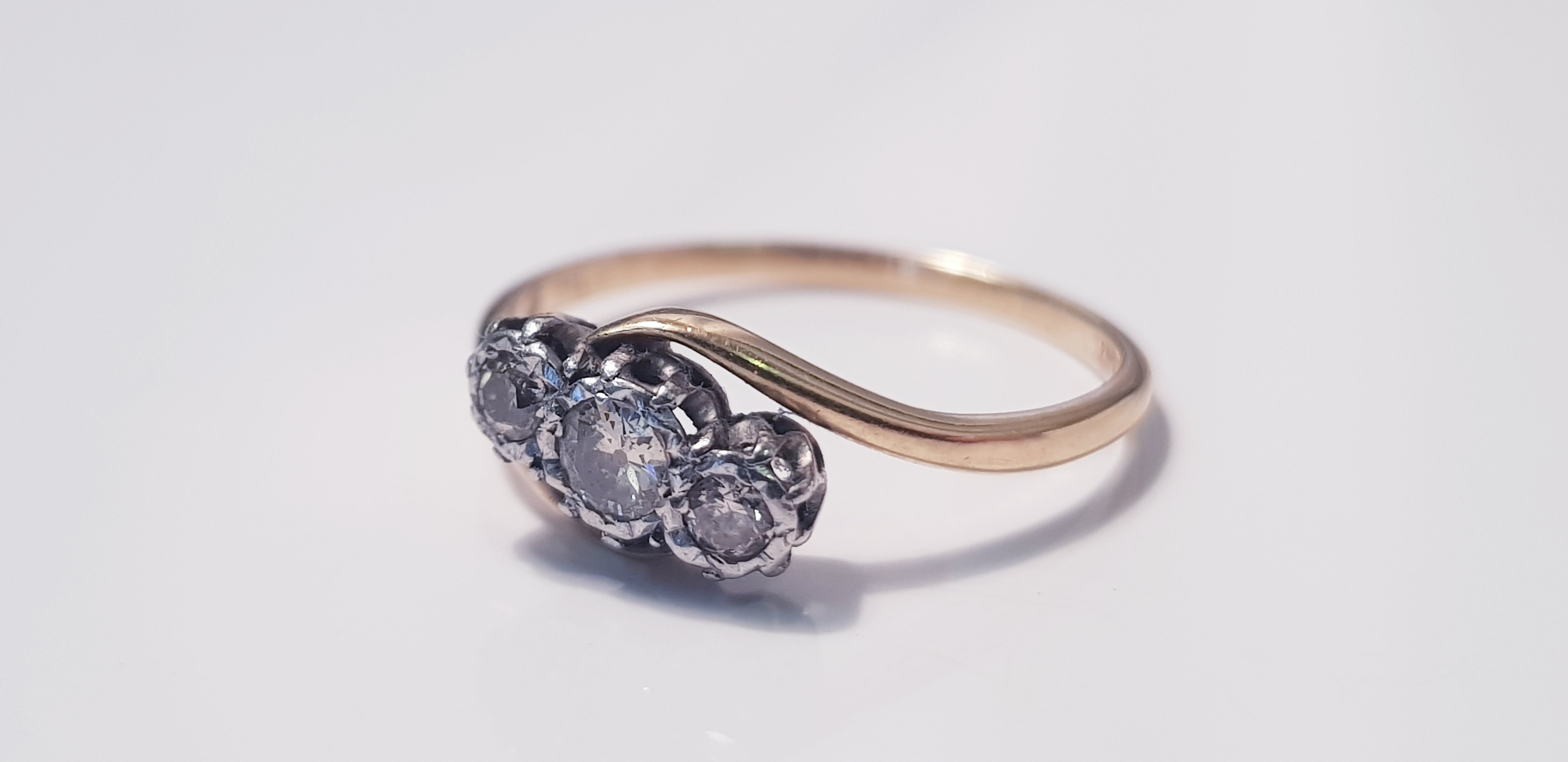 A yellow gold three stone diamond ring on twist, marked 18ct, ring size P1/2, approx. weight 1.