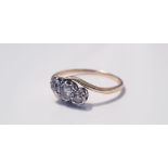 A yellow gold three stone diamond ring on twist, marked 18ct, ring size P1/2, approx. weight 1.